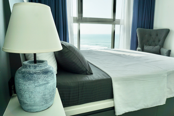 A picture of the apartment's bedroom with a sea view through the window.