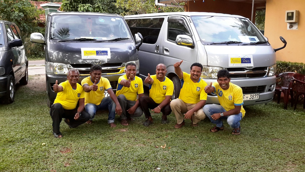 A picture of drivers in front of minibuses in a garden. The local drivers wear Swedish national team shirts. The buses have the Sophie Tours logo on the hood.