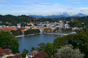 An image of Kandy city in the distance with a small lake in the middle.