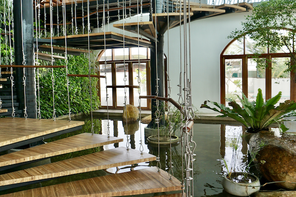A picture of the reception with floating steps, ornamental pond and plants.