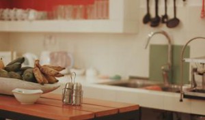 A close-up picture of a kitchen with a kitchen island in the foreground.