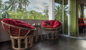 A picture of a table and chairs by a window in the top apartment's living room.